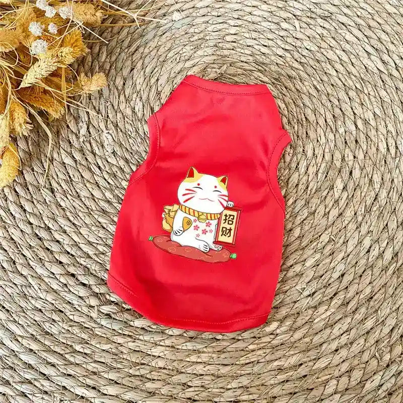 Red pet shirt with a lucky cat holding a gold coin sign on woven mat background