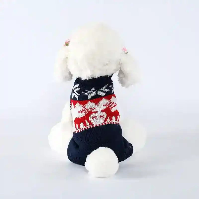 White fluffy dog wearing navy blue and red Christmas sweater with reindeer and snowflake pattern