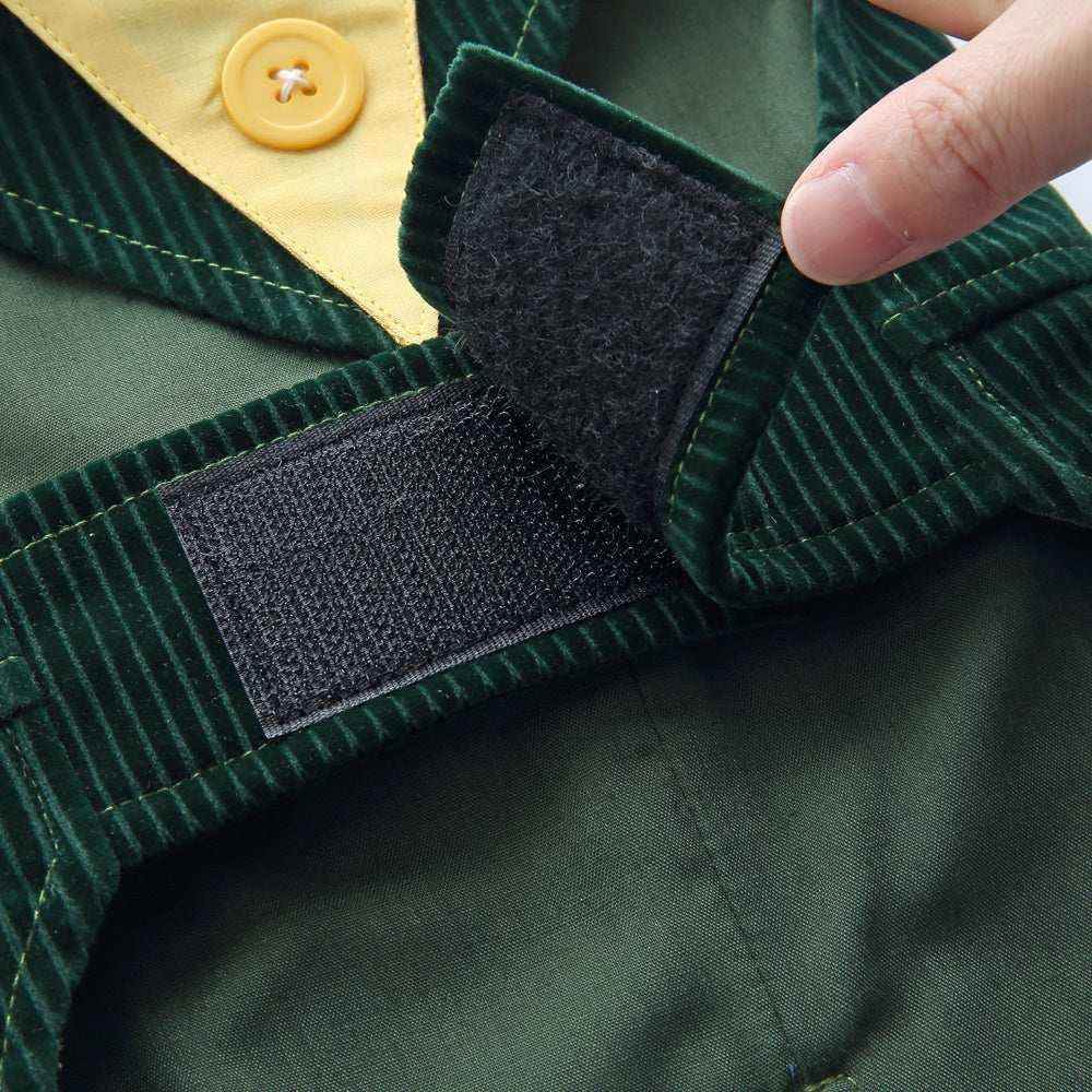 Close-up of green corduroy fabric with black Velcro strip and yellow button detail on clothing