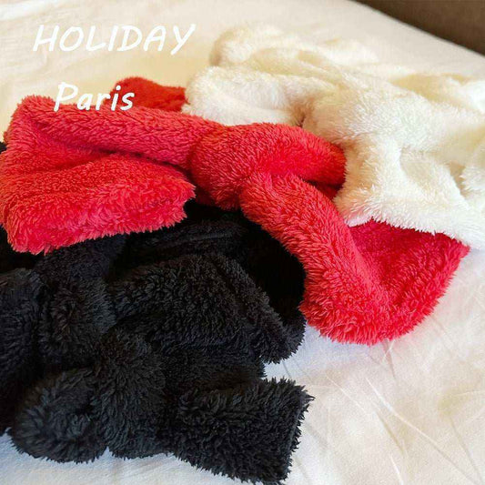 Soft black, red, and white microfiber pet drying towels on a bed with 'HOLIDAY Paris' text