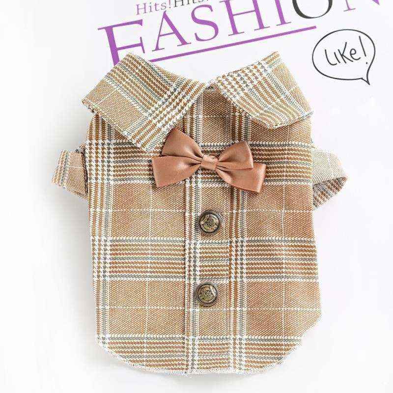 Beige plaid pet shirt with collar, brown bow tie, and decorative buttons on white background