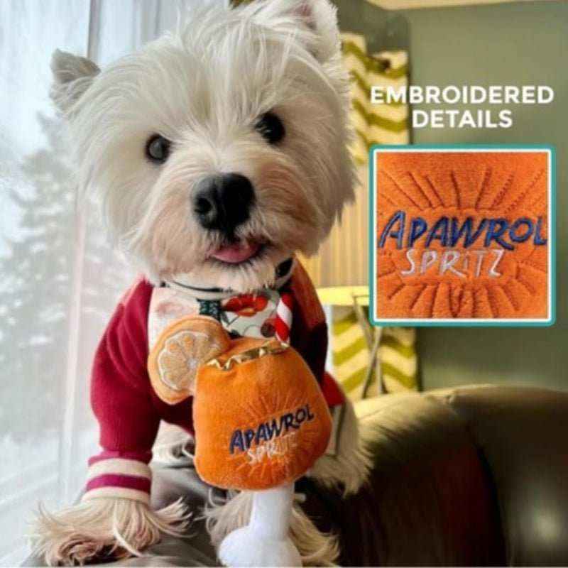 West Highland White Terrier dog wearing red sweater holding Apawrol Spritz plush dog toy with embroidered details