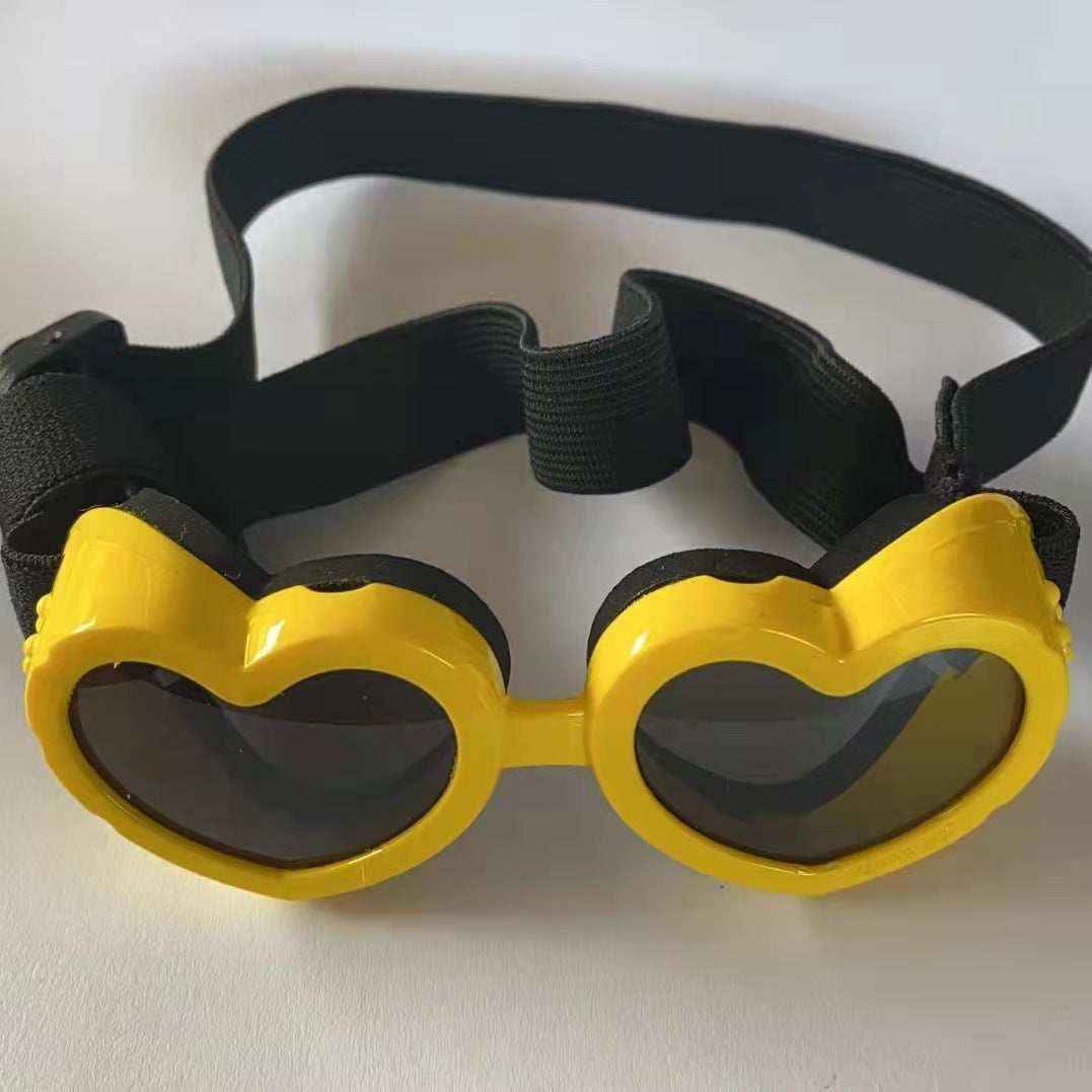 Yellow heart-shaped sunglasses with black lenses and an adjustable black elastic strap