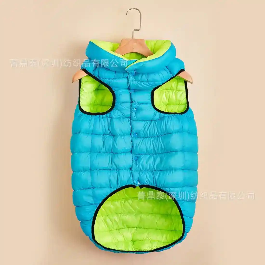 Blue and green padded dog vest with button closure hanging on wooden hanger