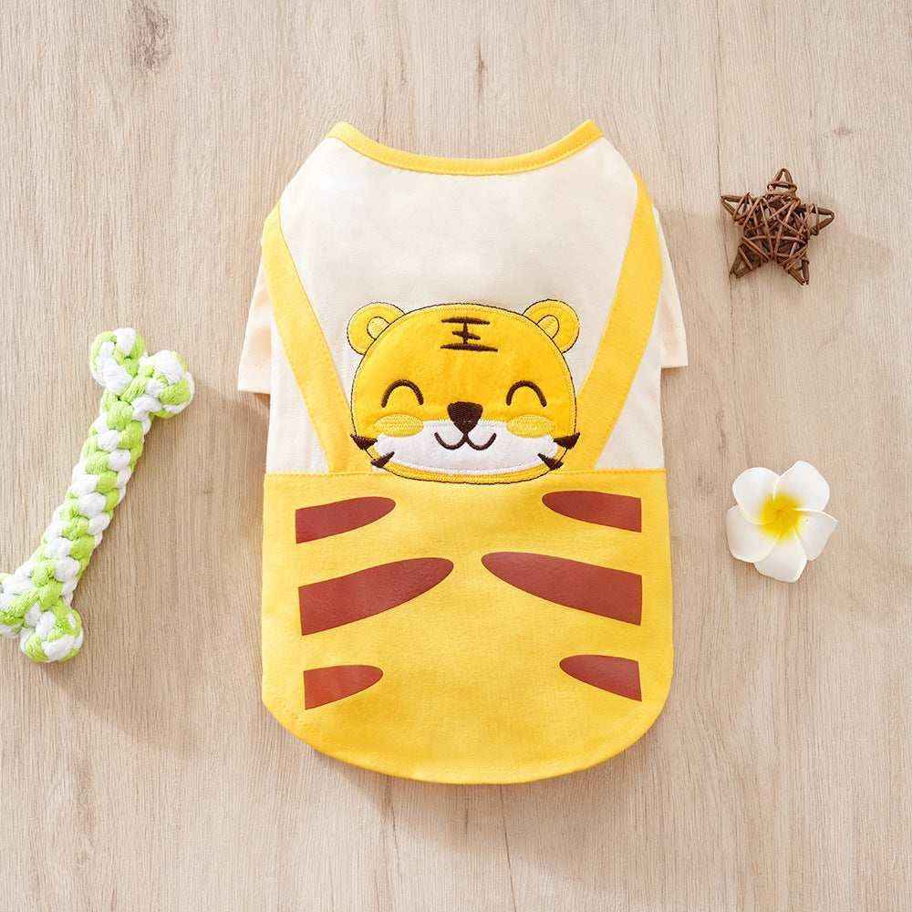 Yellow and white pet shirt with smiling tiger face design on wooden floor with dog toy and decorative star