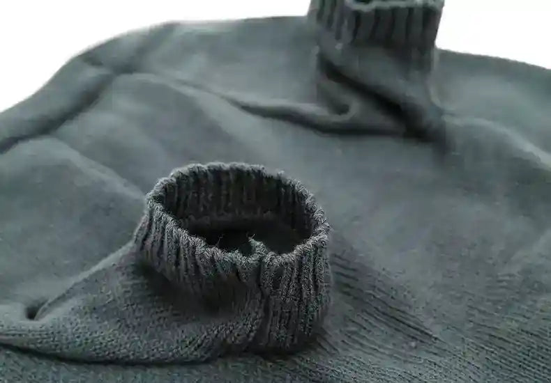 Close-up of folded charcoal gray knitted turtleneck sweater with ribbed collar and cuffs