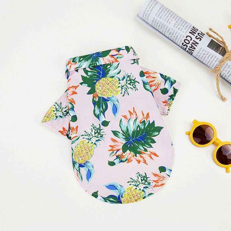 Colorful Hawaiian dog shirt with pineapple and tropical leaf print on white background