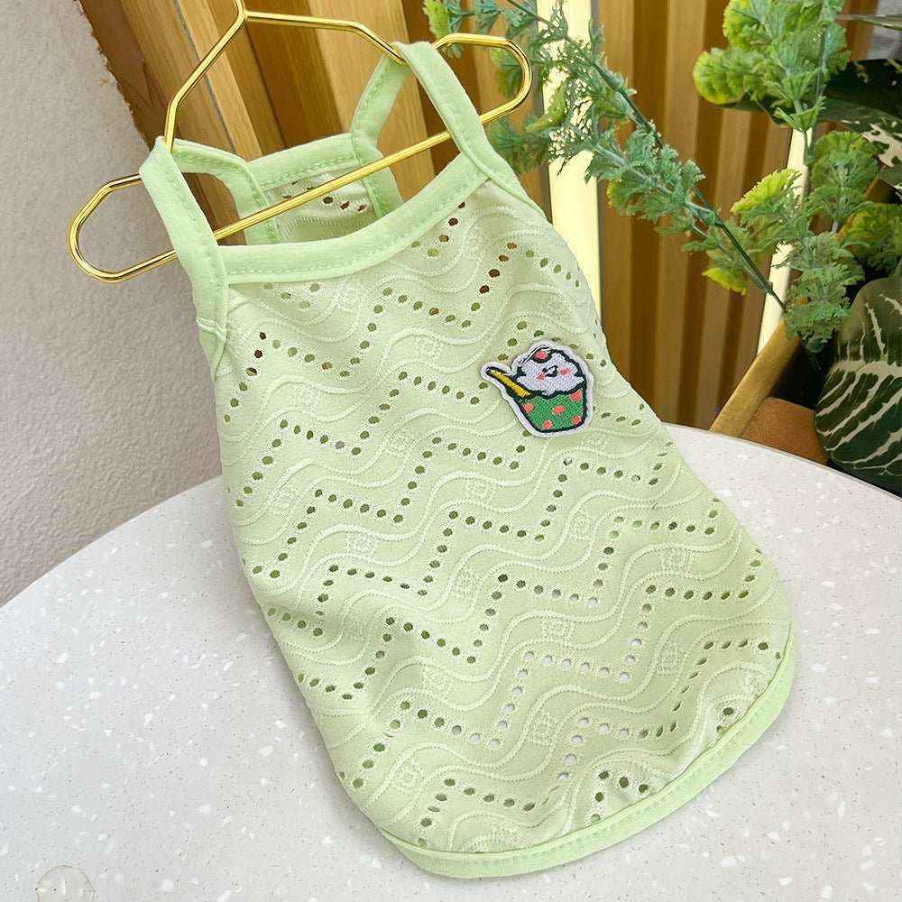 Light green breathable dog vest with decorative cutouts and a small patch, displayed on a gold hanger