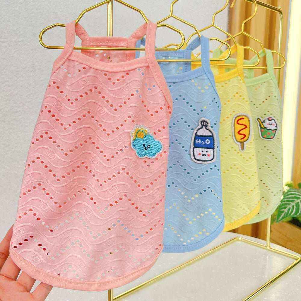 Set of breathable pastel dog tank tops with cute patches, hanging on gold hangers indoors