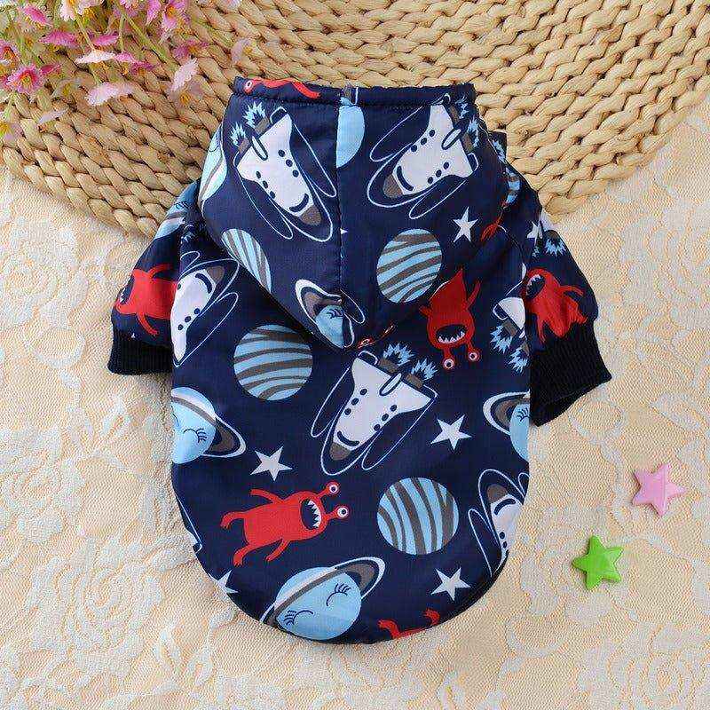 Navy blue dog hoodie with space-themed print including planets and aliens on beige textured background