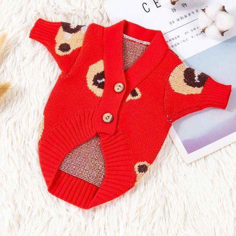 Red knitted dog cardigan with bear face pattern and two wooden buttons on a white fur background