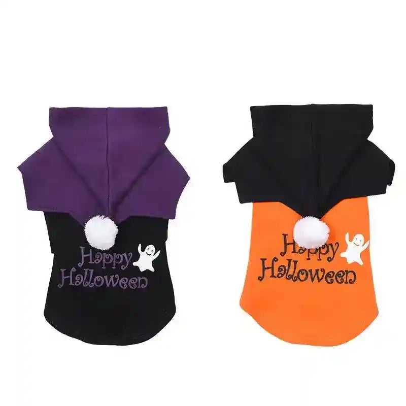 Two Halloween dog hoodies with ghost prints and pom-poms, one black with purple hood, one orange with black hood