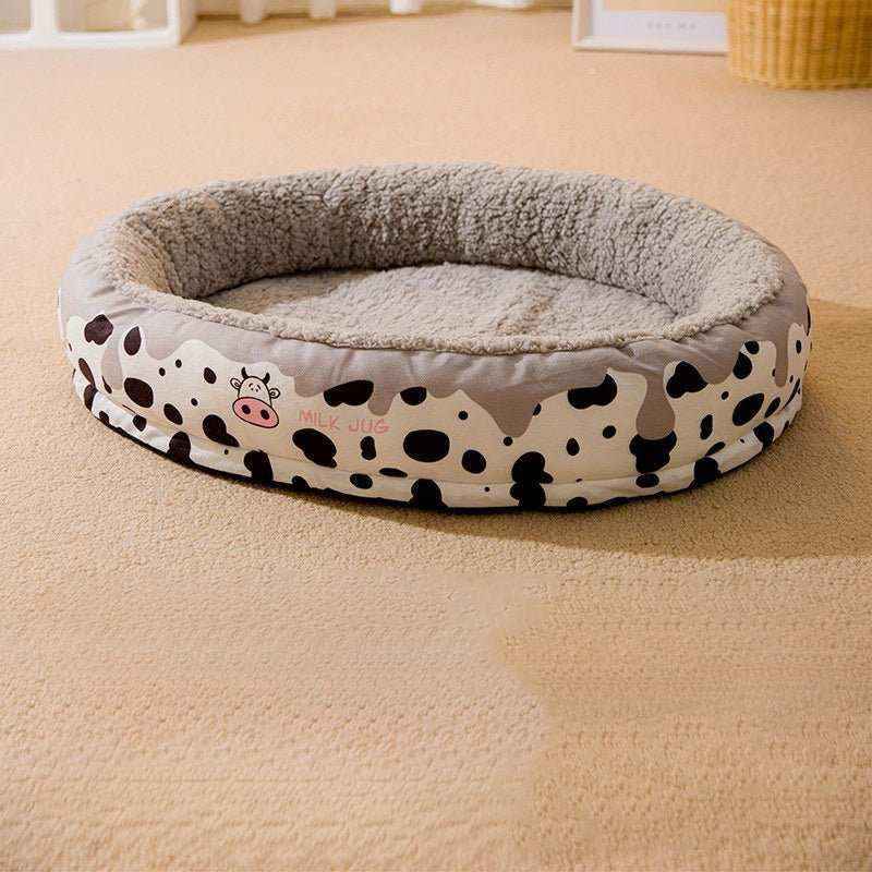 Round cozy dog bed with soft gray interior and cow print exterior design on beige carpet