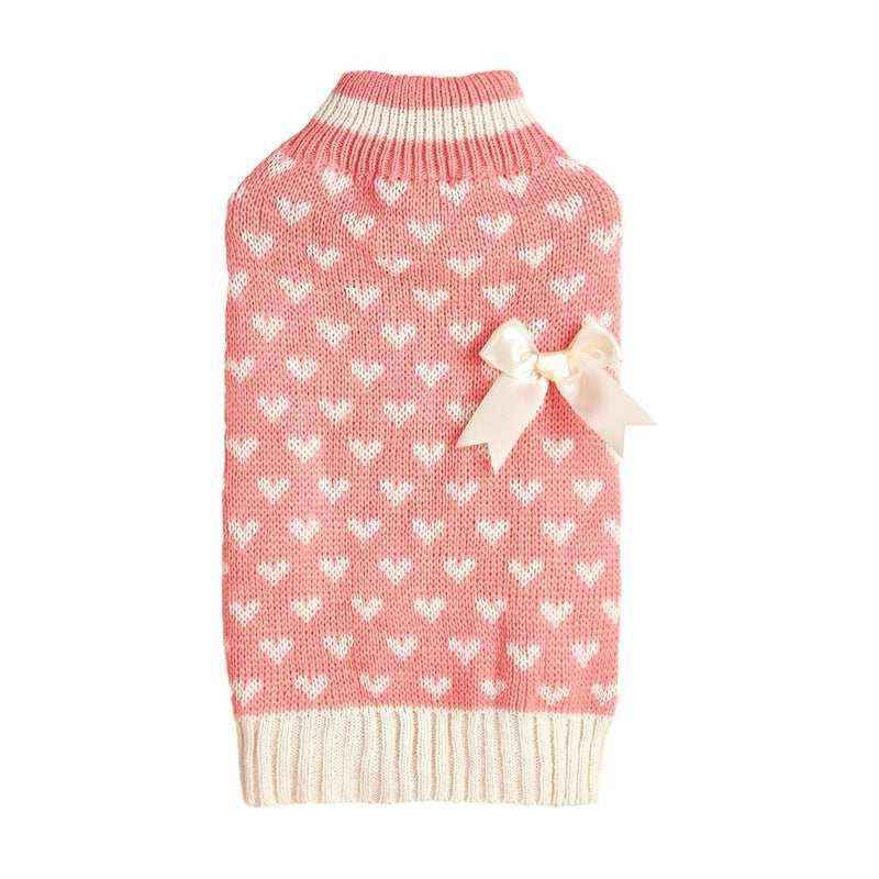 Pink knitted dog sweater with white heart patterns, ivory ribbed collar and hem, and a decorative ivory bow