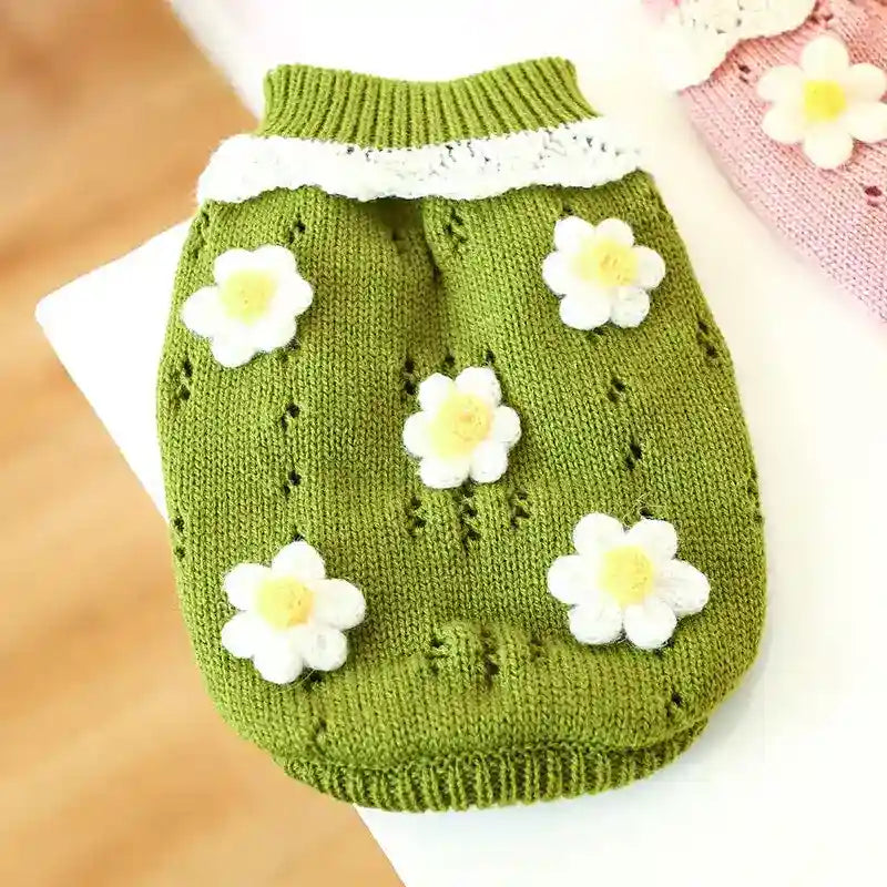 Green knitted dog sweater with white and yellow flower appliques and a white collar detail