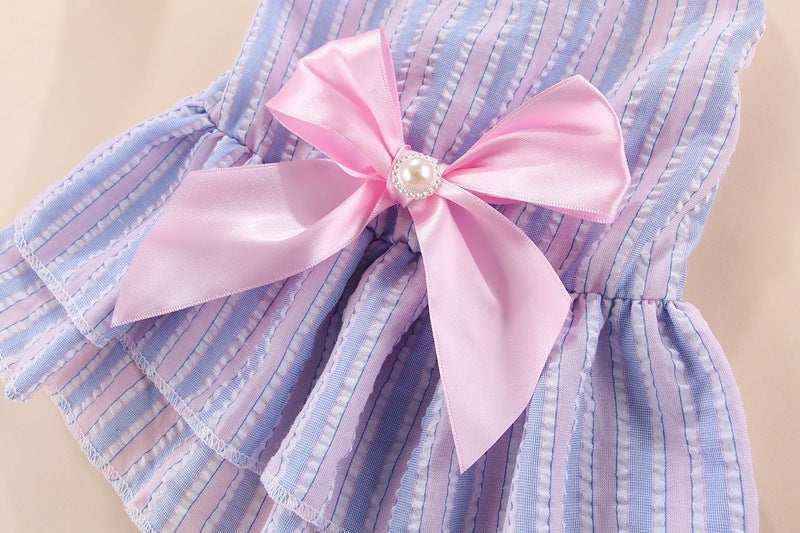 Purple striped baby dress with pink satin bow and pearl detail on beige background