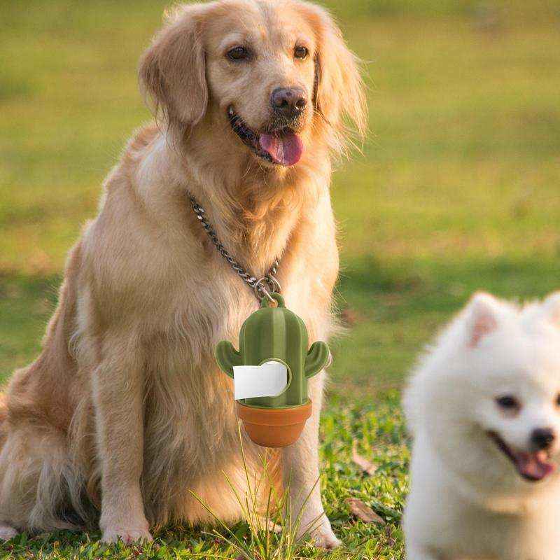 Golden retriever sitting on grass with a green cactus-shaped dog waste bag dispenser attached to its collar