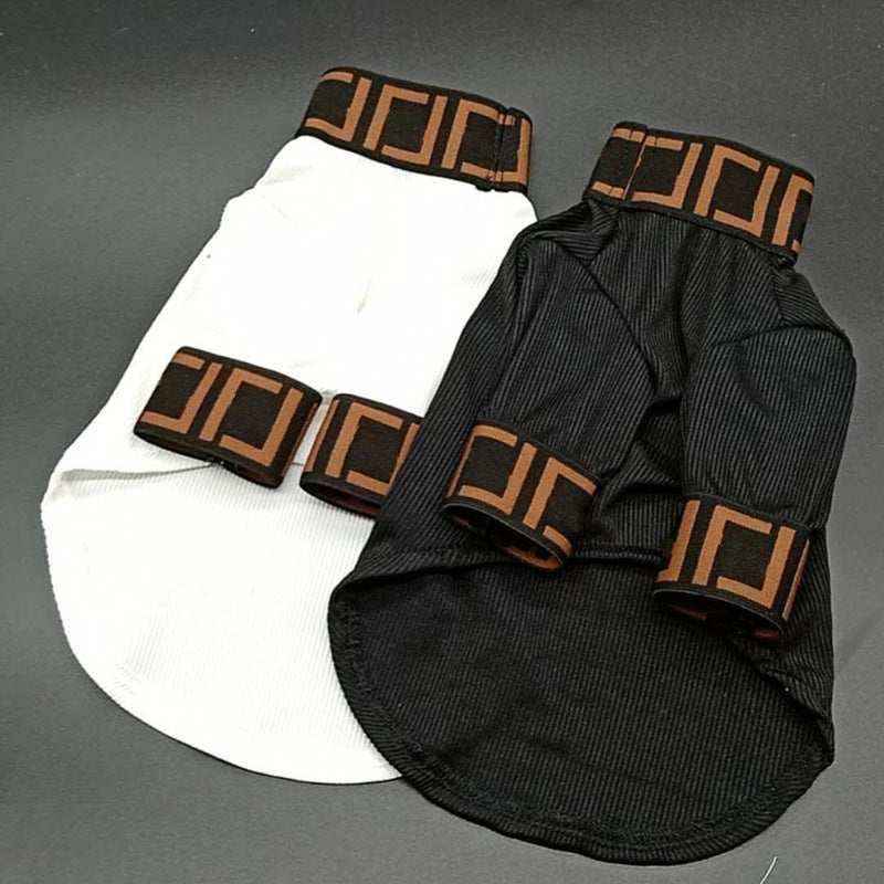 Black and white dog sweaters with brown and black geometric patterned collars and sleeves on gray background