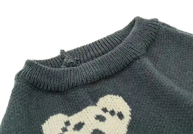 Close-up of dark gray knit sweater with ribbed collar and white bear face design