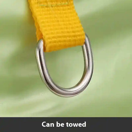 Close-up of yellow nylon strap attached to silver metal D-ring on green surface, towing feature