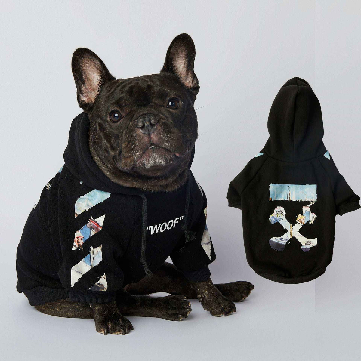 Black French Bulldog wearing black hoodie with 'WOOF' text and graphic print on sleeves and back