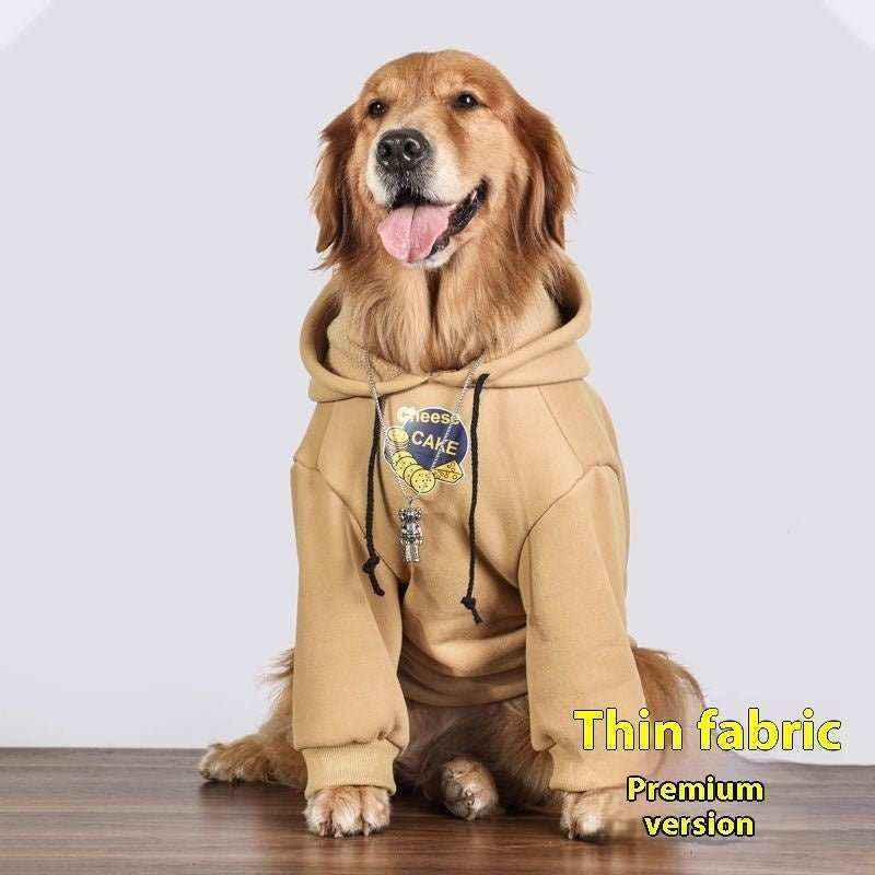 Golden retriever dog wearing stylish tan hoodie with cheese cake print sitting on wooden floor