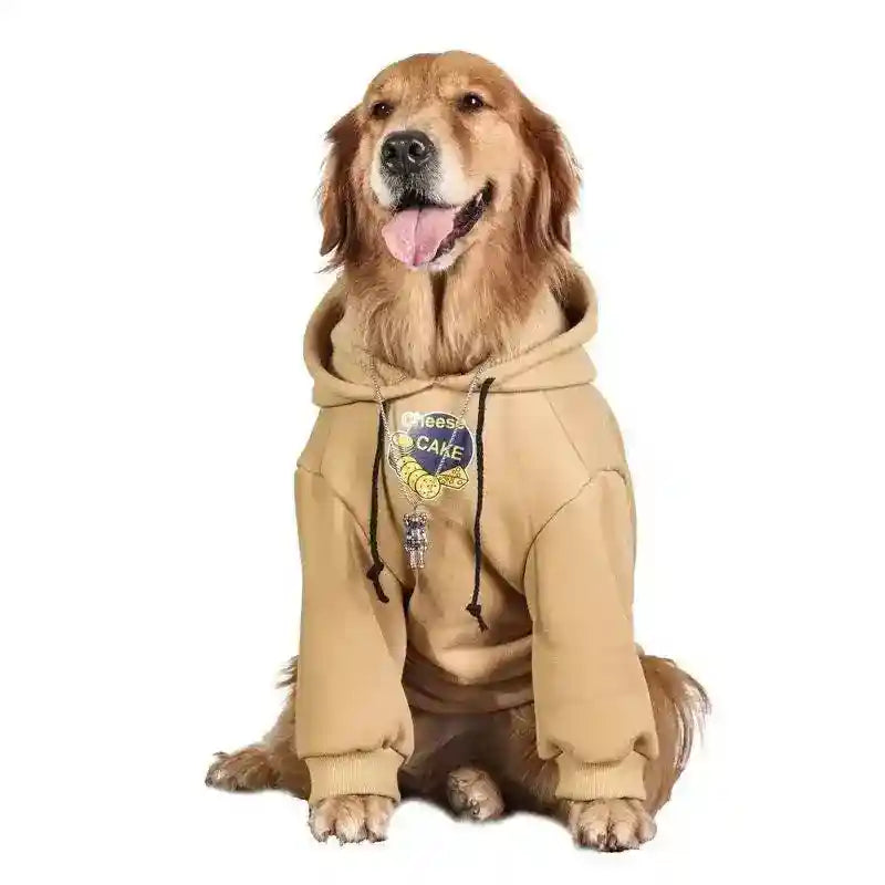 Golden retriever dog sitting wearing beige hoodie with cheese cake graphic and pendant necklace