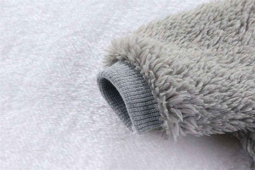 Close-up of a grey cozy fleece sleeve with ribbed cuff on soft fabric background