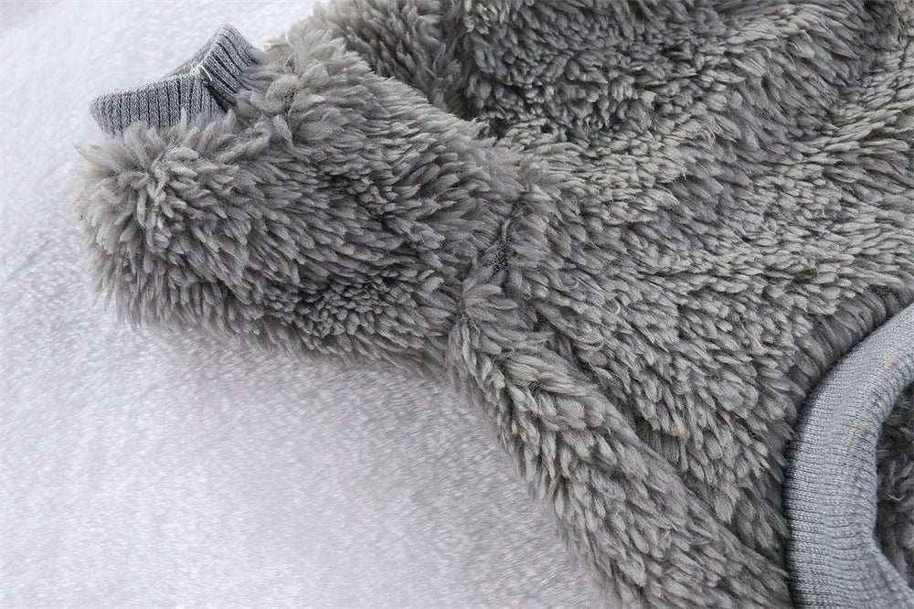 Close-up of a soft grey fluffy pet jacket with knit cuffs for small dogs on a light background