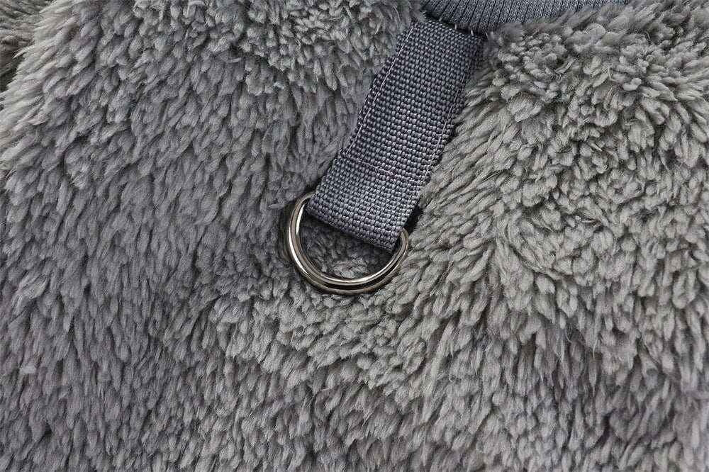 Close-up of gray fluffy pet bed with attached gray strap and metal ring