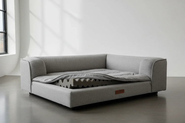 Orthopedic padded dog bed with removable grey cover and egg crate foam in bright room