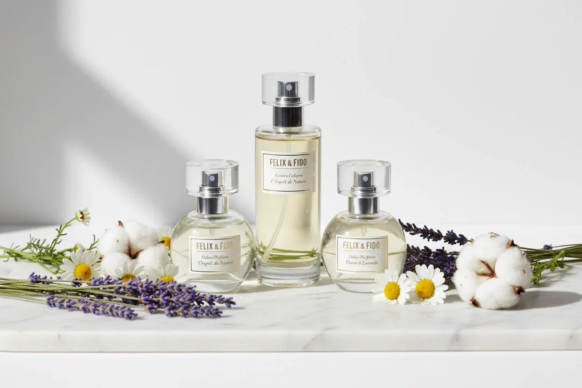 Felix & Fido pet perfume bottles on marble with lavender, chamomile, and cotton flowers