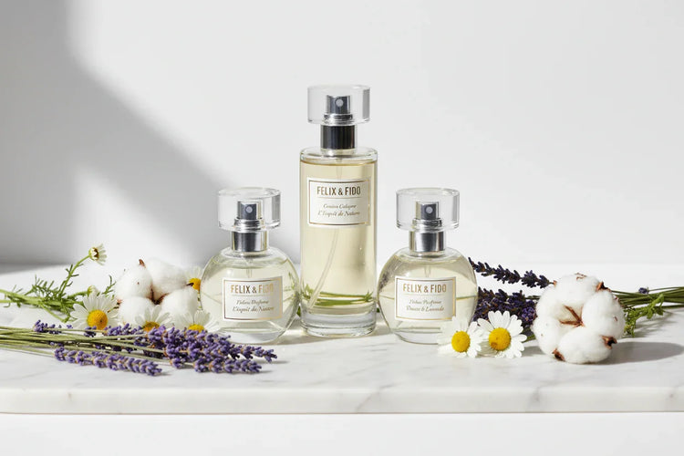 Felix & Fido pet perfume bottles on marble with lavender, chamomile, and cotton flowers