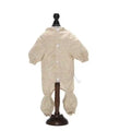 Beige and white polka dot baby onesie with long sleeves and gathered cuffs on display stand