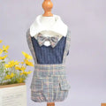 Plaid suspender skirt with matching bow tie and white collar over navy knit top on mannequin