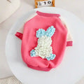 Pink and cream dog sweater with blue and white textured bunny design on back