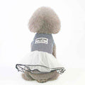 Small fluffy dog wearing striped blue top and white tulle skirt dress, back view