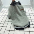Gray dog sweater with checkered collar and cuffs on white grid background