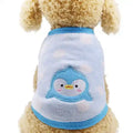 Fluffy beige dog wearing a light blue fleece pet sweater with a cute penguin patch on the back