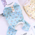 Floral print baby blue and cream knit rompers with button details on white surface
