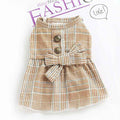 Beige plaid pet dress with decorative buttons and bow detail on white background with fashion text