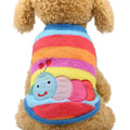 Small dog wearing colorful striped sweater with smiling caterpillar design