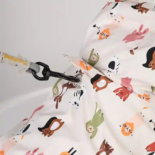 Close-up of a white fabric bag with colorful animal prints and a black clip attached to a gray rope