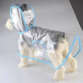 Small dog wearing transparent waterproof raincoat with blue trim on plain background