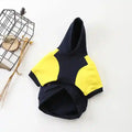 Navy blue and yellow short-sleeve dog hoodie on white background with decorative birdcage and dried flowers