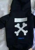 Black dog hoodie with white crossed bones graphic and blue text 'TREATS' on soft blanket